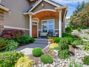 A beautiful front covered patio with an inviting seating area, surrounded by tasteful landscaping and well-maintained garden for a polished and tailored curb appeal
