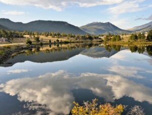 An image of a lake in Estes Park with a reflection of the sky and mountains.