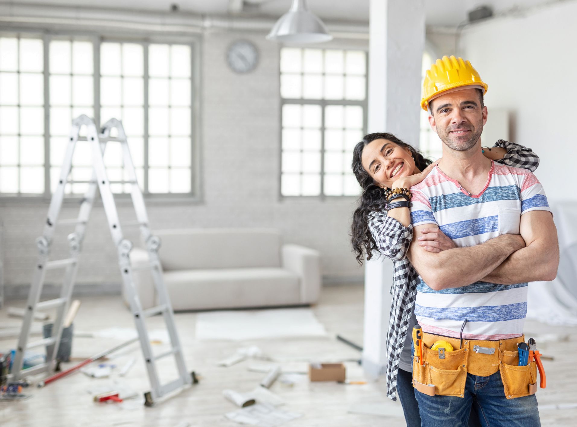 This is an image of a man and women standing in their living room that is being renovated