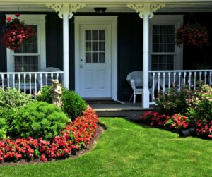 This is an image of the front of a house with flowers and bushes.