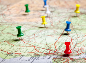This is an image of a road map with thumbtacks marking different cities