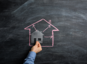 This is an image of a chalkboard with a picture of a house drawn in pink.
