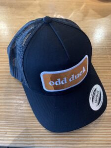 Blue trucker hat with a brown patch that says "odd duck"