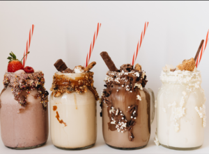 This is an image of 4 milkshakes in mason jars.