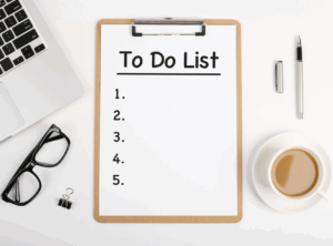 This is an image of a to-do list on a clipboard with a pair of glasses on one side and a cup of coffee on the other.