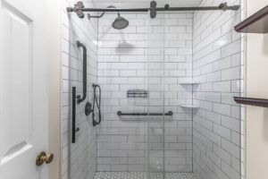 Updated walk-in shower with subway tile and glass door.