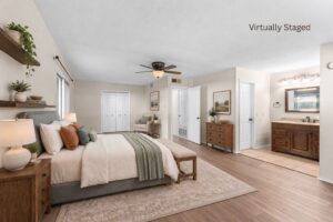 Virtually staged primary bedroom with hard flooring, ceiling fan, closet doors, and adjoining bathroom vanity at 2100 Kippling Drive.